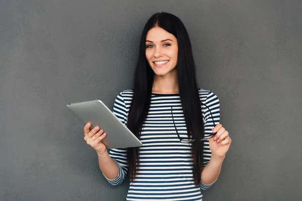 Mujer sonriente sosteniendo la tableta digital — Foto de Stock