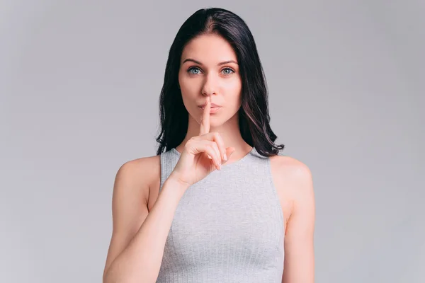 Woman holding finger on lips — Stock Photo, Image