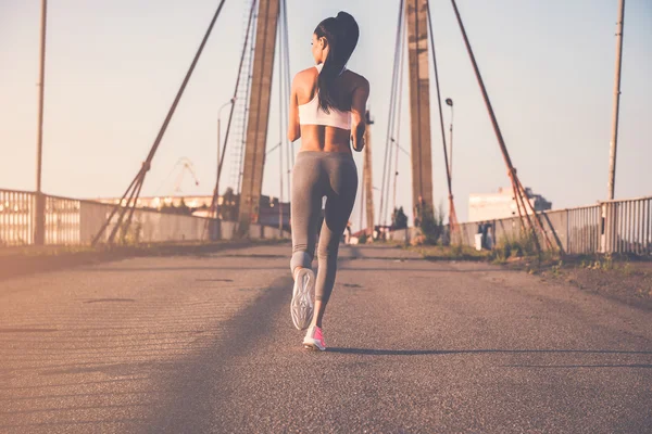 Mujer corriendo por el puente — Foto de Stock