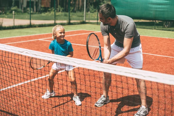 Padre enseñando a su hija a jugar tenis — Foto de Stock