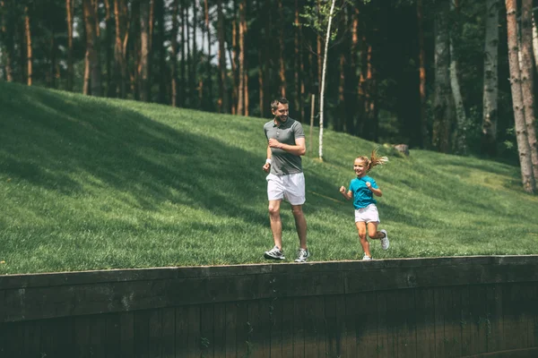 Vader en dochter joggen in het park — Stockfoto