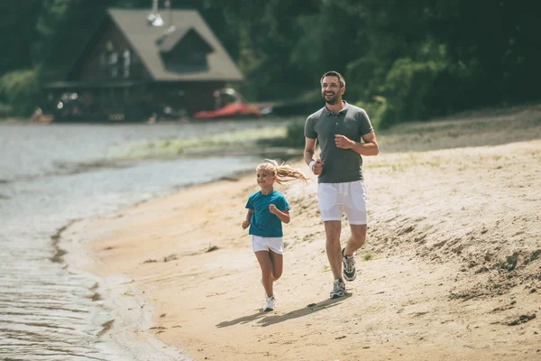 Far och dotter jogging på åstranden — Stockfoto