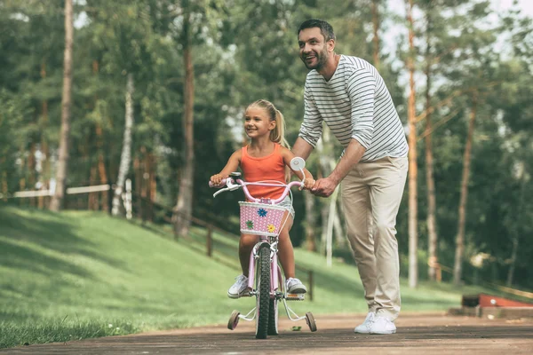 Pai ensinando sua filha a andar de bicicleta — Fotografia de Stock