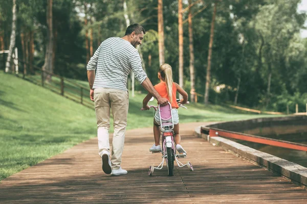 Pai ensinando sua filha a andar de bicicleta — Fotografia de Stock