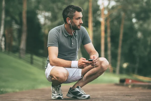 Man crouching in park