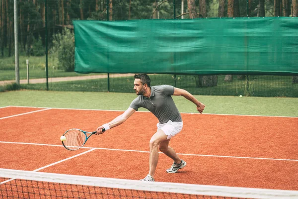 Человек играет в теннис — стоковое фото