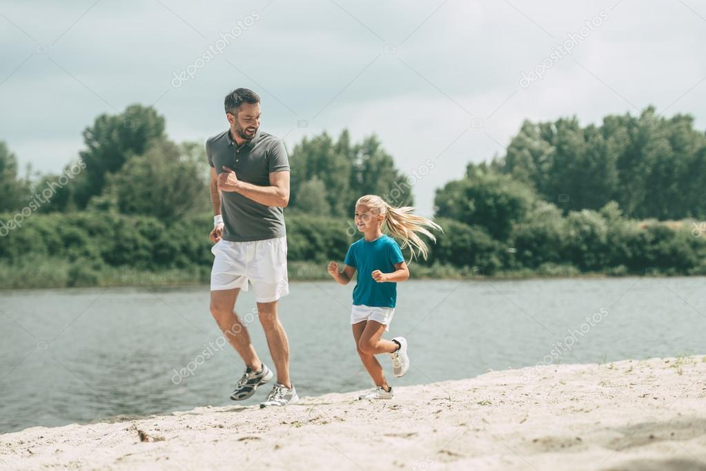 Father and daughter jogging at the riverbank 