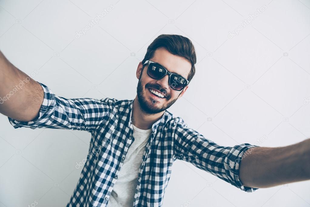 Man in sunglasses making selfie