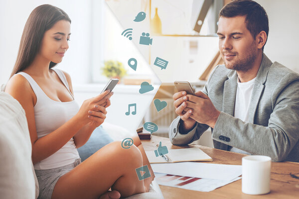 Мужчина и женщина смотрят на смартфоны
 