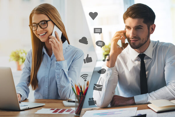 Мужчина и женщина разговаривают на смартфонах
 