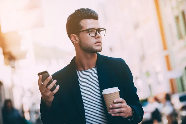 Uomo in possesso di caffè e smartphone — Foto Stock