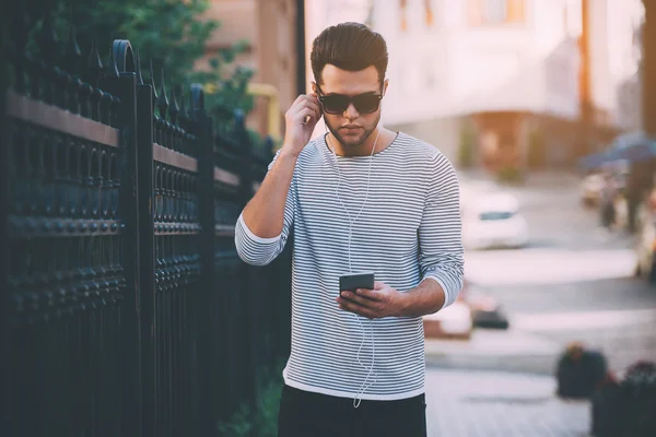 Hombre ajustando sus auriculares —  Fotos de Stock