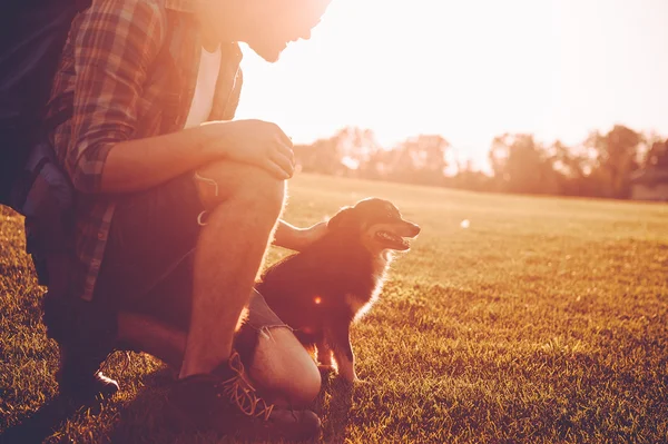 man with backpack petting dog