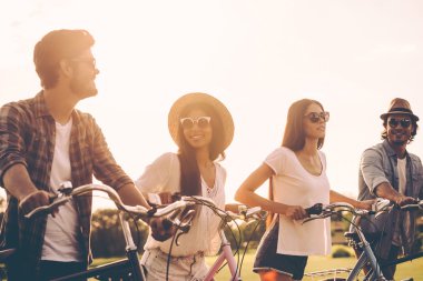 young people pushing their bicycles 