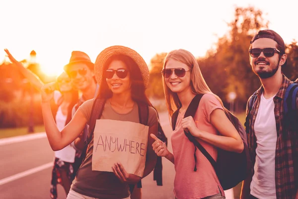 Young people with backpacks hitchhiking — Stockfoto