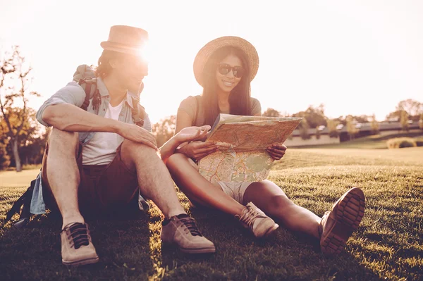 Jovem casal com mochilas examinando mapa — Fotografia de Stock