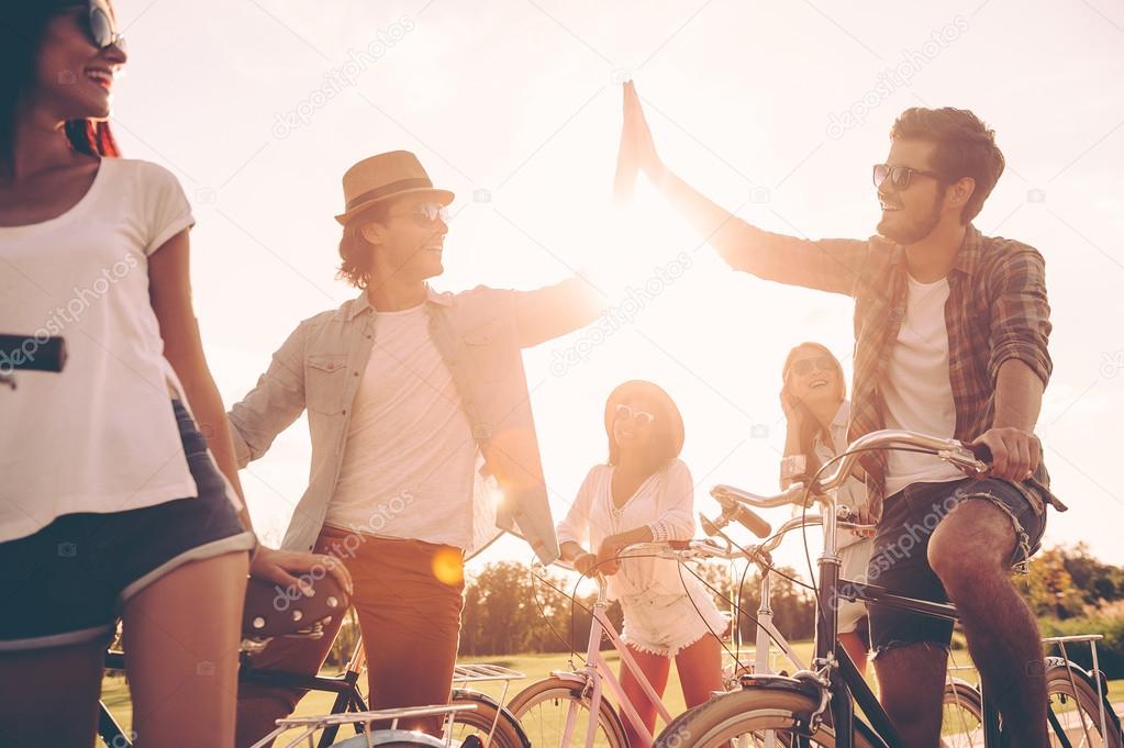  young people standing near their bicycles 