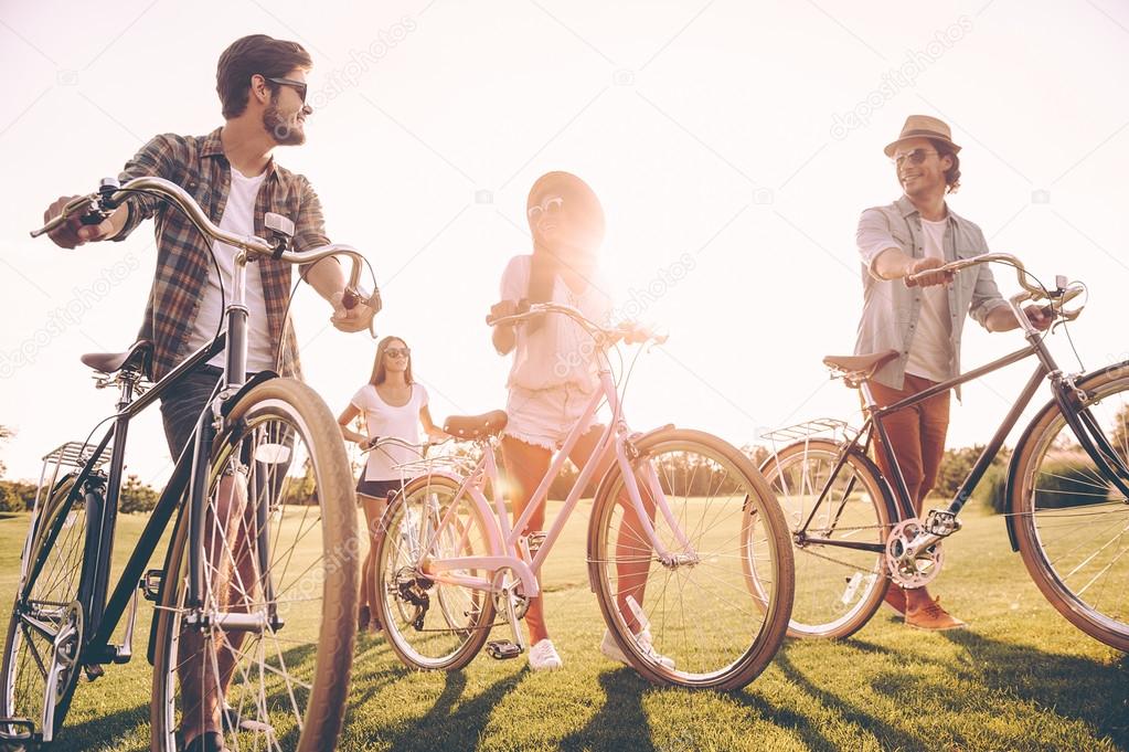 young people pushing their bicycles 