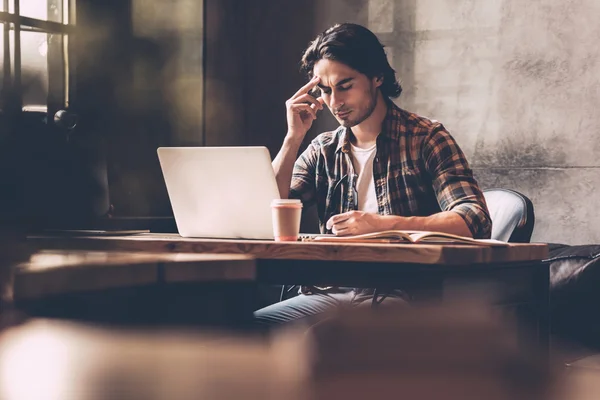 Jovem sentado no seu local de trabalho — Fotografia de Stock