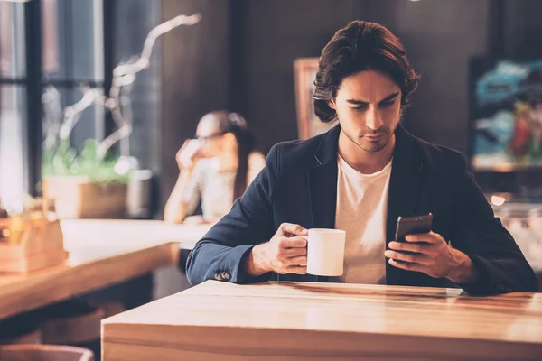 Hombre joven sosteniendo el teléfono inteligente — Foto de Stock