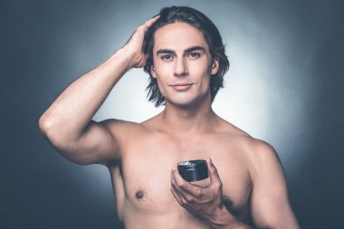 shirtless man applying hair gel  clipart