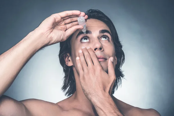 Homem colocando gotas nos olhos — Fotografia de Stock