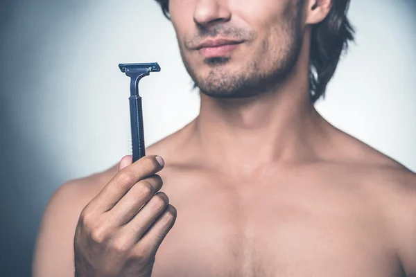 Homem segurando navalha e expressando negatividade — Fotografia de Stock