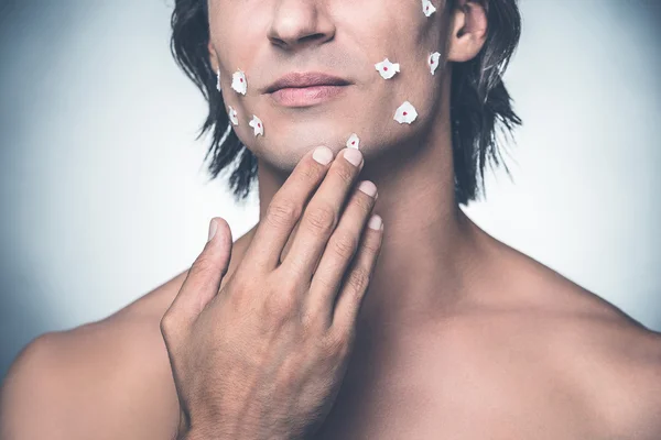 Giovane uomo senza maglietta che si tocca il viso — Foto Stock