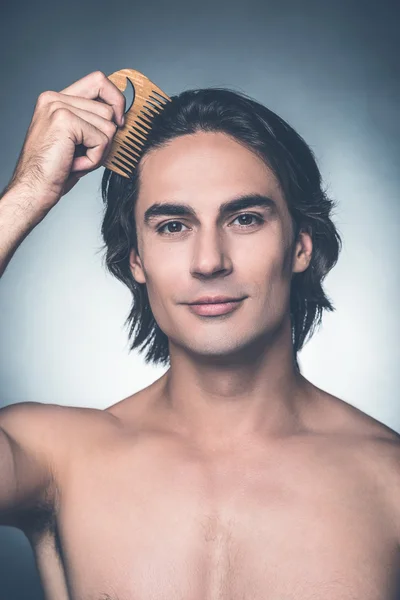 Shirtless man combing his hair — Stock Photo, Image