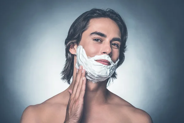 Hombre propagación de crema de afeitar sobre la cara — Foto de Stock