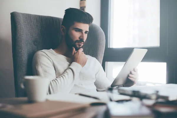 Handsome man browsing digital tablet — Stock Photo, Image