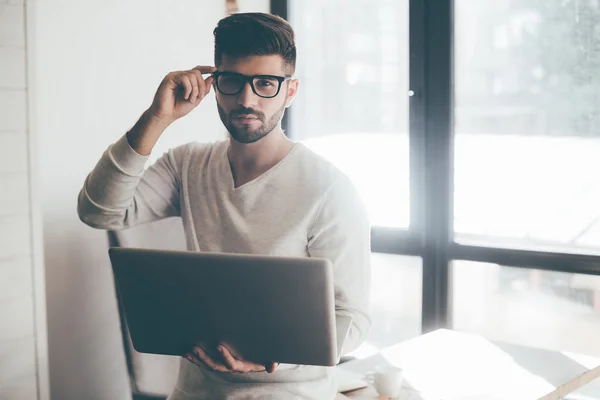 Homem bonito segurando laptop na mão — Fotografia de Stock