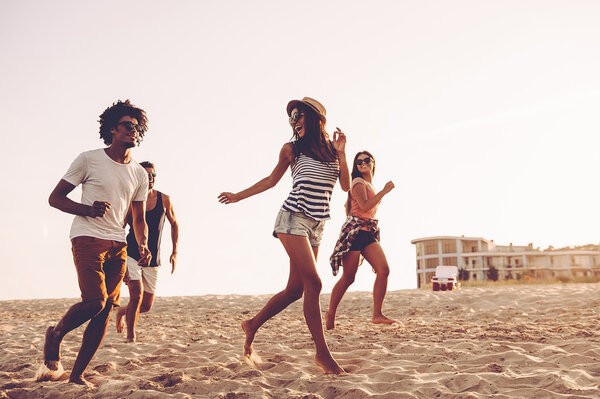 young people running at beach 