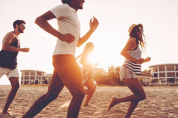 Junge Leute rennen am Strand — Stockfoto