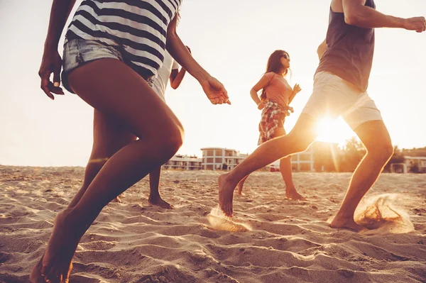 Junge Leute rennen am Strand — Stockfoto