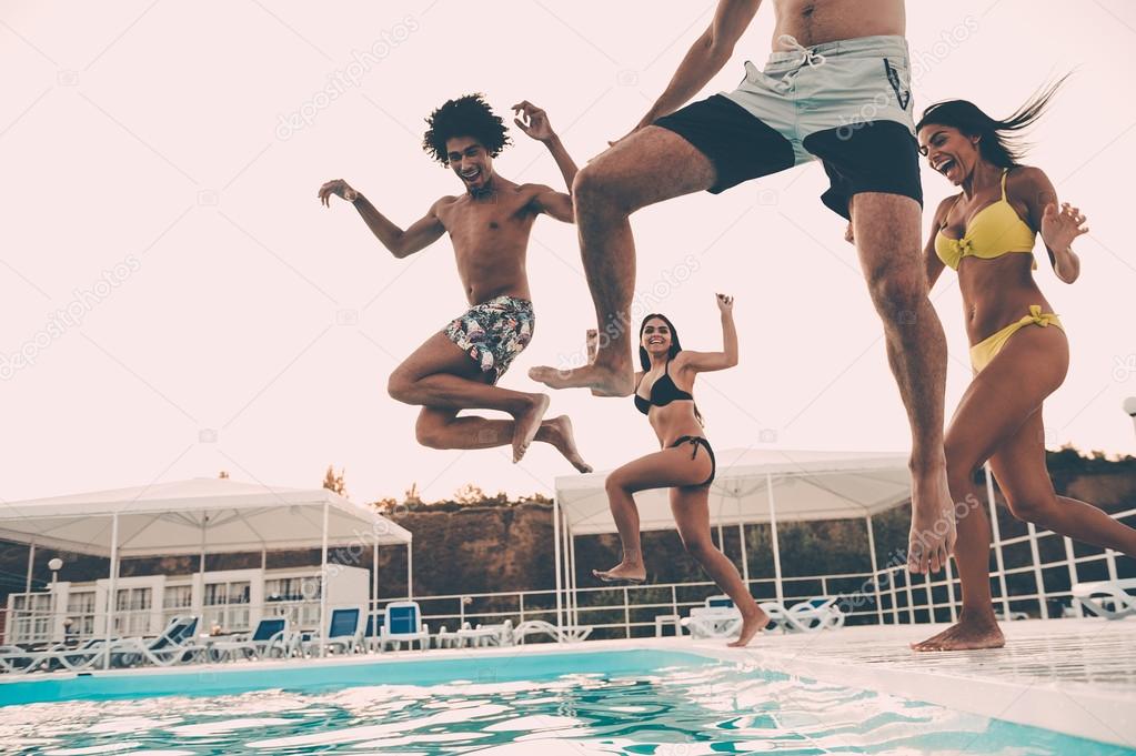 best friends jumping into swimming pool
