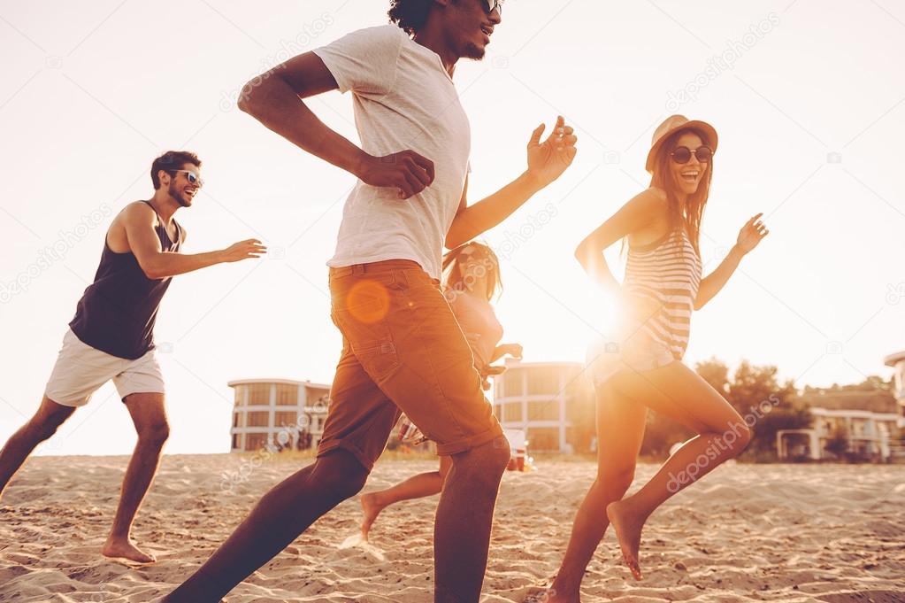 young people running at beach 