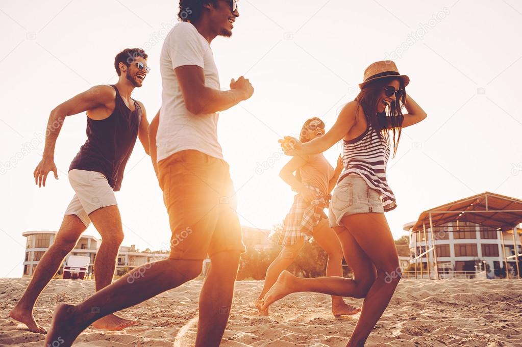 young people running at beach 