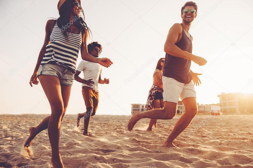 young people running at beach 