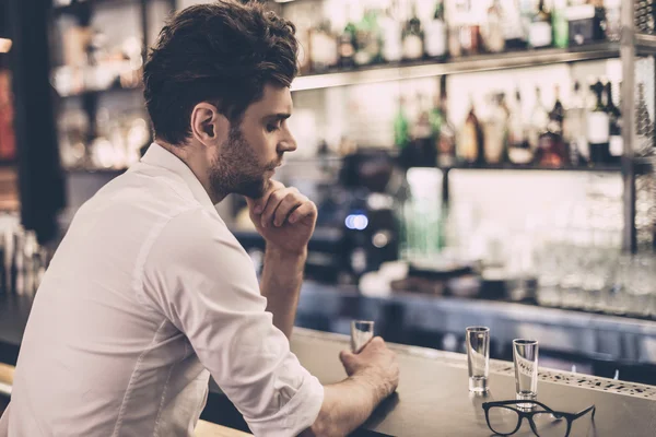 Homem de camisa sentado no balcão do bar — Fotografia de Stock