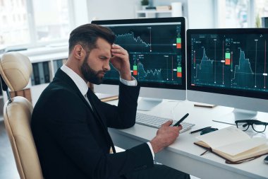 Ofiste çalışırken duygusal stres yaşayan, resmi giysili üzgün genç bir adam.