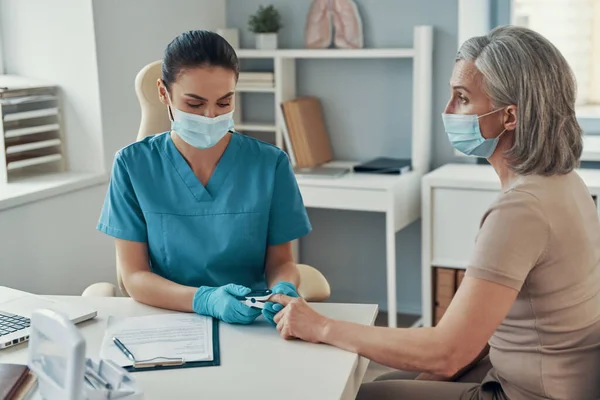 Young female nurse using monitoring equipment — Stock Photo, Image