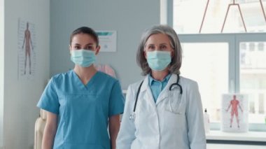 İki mutlu kadın doktor üniforması giyiyor.