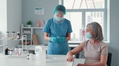 Genç bayan hemşire aşı yapıyor. 