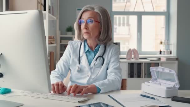 Впевнена зріла жінка-лікар в білому лабораторному пальто — стокове відео