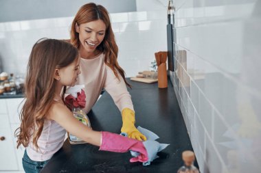 Anne ve kızı evde vakit geçirirken bulaşık eldiveni kullanıyor.