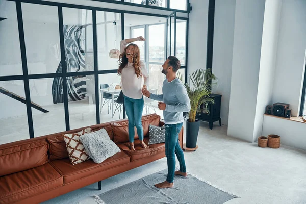 Volledige lengte van jong vrolijk paar glimlachen en dansen terwijl bonding samen thuis — Stockfoto