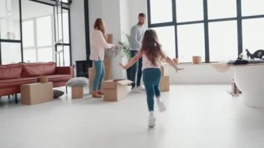 Mutlu genç aile birlikte eğleniyor ve eşyaları yerleştiriyor. 