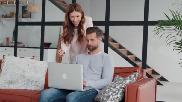 Красивая молодая пара разговаривает с кем-то по видео конференции на ноутбуке — стоковое видео