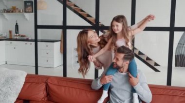 Mutlu, genç bir aile evde birbirimize bağlanırken gülümsüyor ve kucaklaşıyoruz.